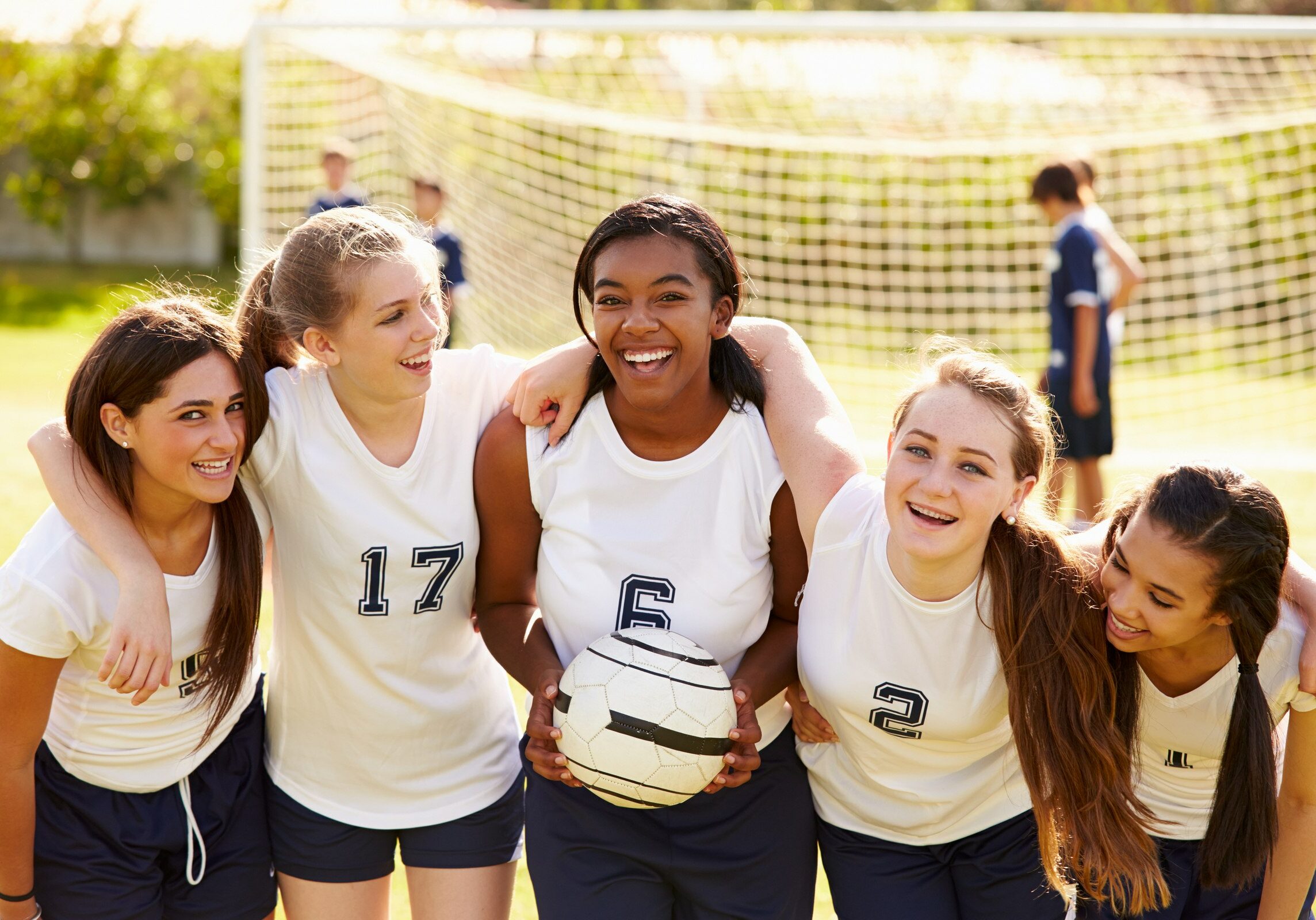Members Of Female High School Soccer Team Smiling To Camera